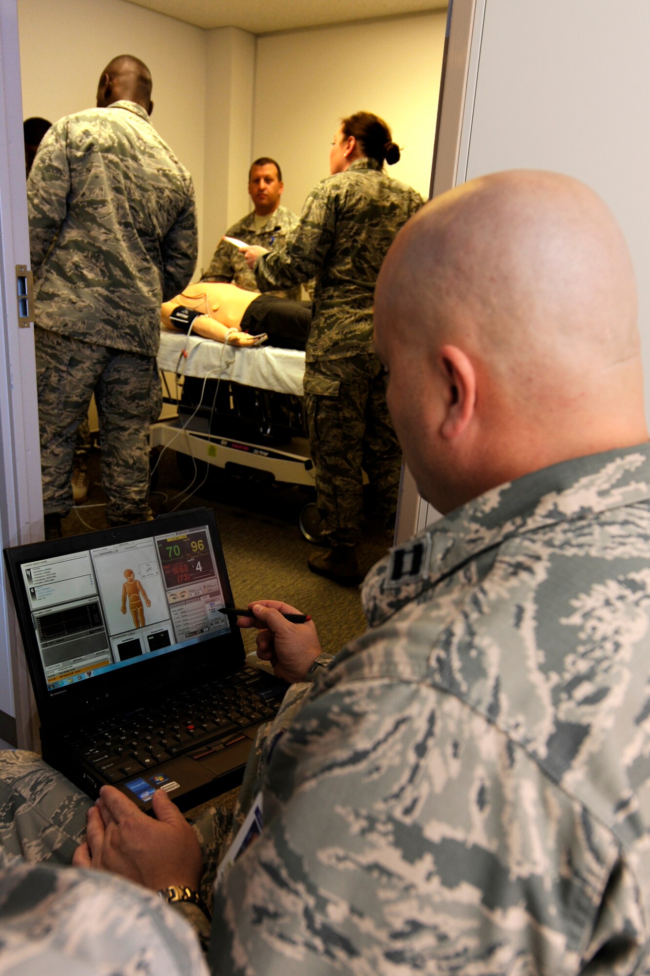U.S. Air Force Capt. Donald Tritz, 18th Medical Group chief of education and training, operates a SimMan 3G while Army 1-1 Air Defense Artillery medics and 18th Medical Operations Squadron Airmen perform advanced cardiac life support on Kadena Air Base, Japan, Sept. 18, 2014. The SimMan 3G allows medical practitioners to experience realistic scenarios and can simulate anything a person can do, to include talking, crying, salivating and bleeding. (U.S. Air Force photo by Senior Airman Marcus Morris/Released)