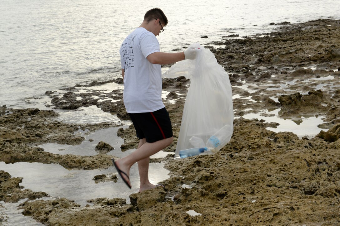 Staff Sgt. Caleb Nolen, deployed to the 36th Expeditionary Aircraft Maintenance Squadron from Barksdale Air Force Base, La., picks up plastic bottles during the International Coastal Cleanup Sept. 20, 2014, at Tarague Beach on Andersen Air Force Base, Guam. More than 100 volunteers gathered to clear several pounds of trash and recyclables from the base beaches. (U.S. Air Force photo by Tech. Sgt. Zachary Wilson/Released)