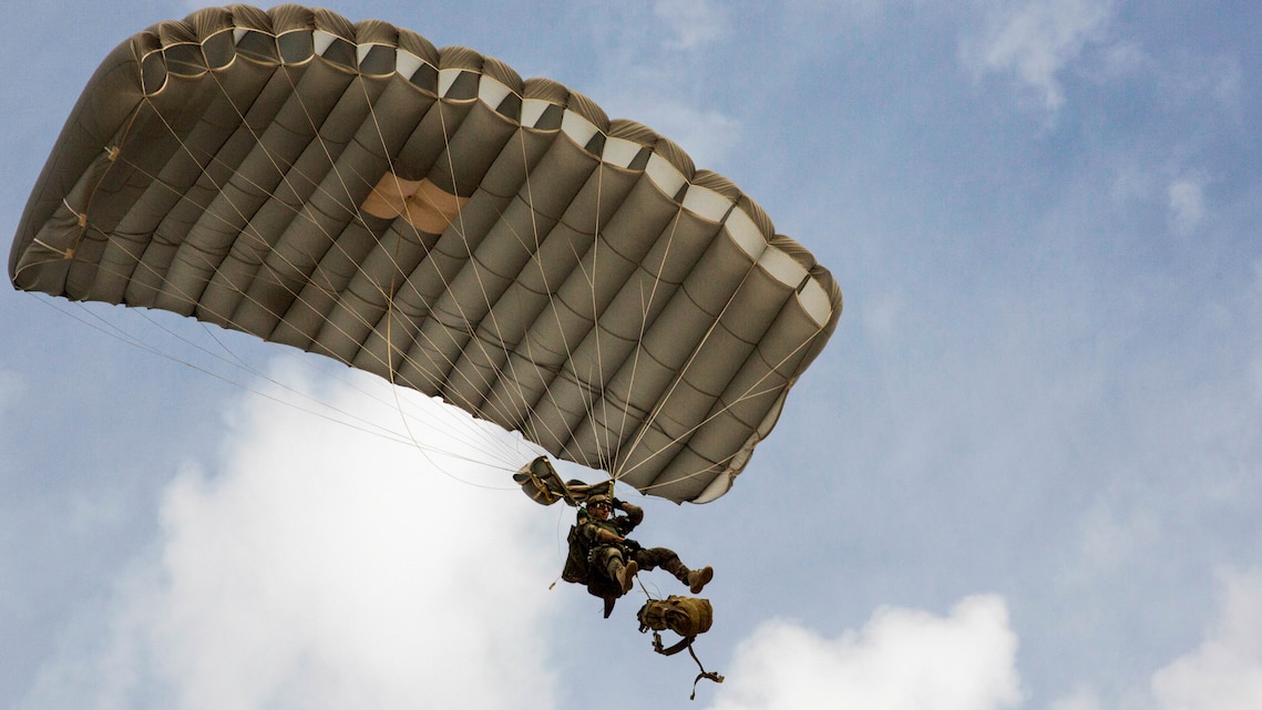 A U.S. Marine Critical Skills Operator with 1st Marine Special Operations Battalion, Marine Corps Forces, Special Operations Command, releases his ruck sack from his body, preparing to land during a double-bag static line parachute training course , Aug 26, 2014, in rural Arizona. The course was an introduction to the High Altitude, High Opening insertion method utilized by Special Operations Forces. 