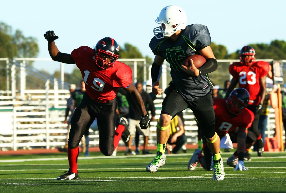 Marine Corps Base Spartans' Bryce Pruitt scores a touchdown against the Miramar Falcons during a Commanding General's Cup football game at the Paige Fieldhouse football field, Sept. 23. The Spartans defeated the Falcons with a score of 34-0. (Photo by Cpl. Shaltiel Dominguez)