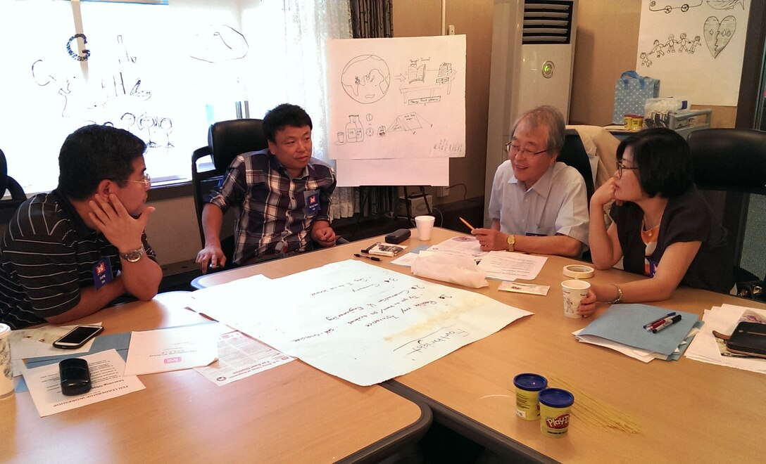 Far East District employees discussing district's mission and vision in a small group. 