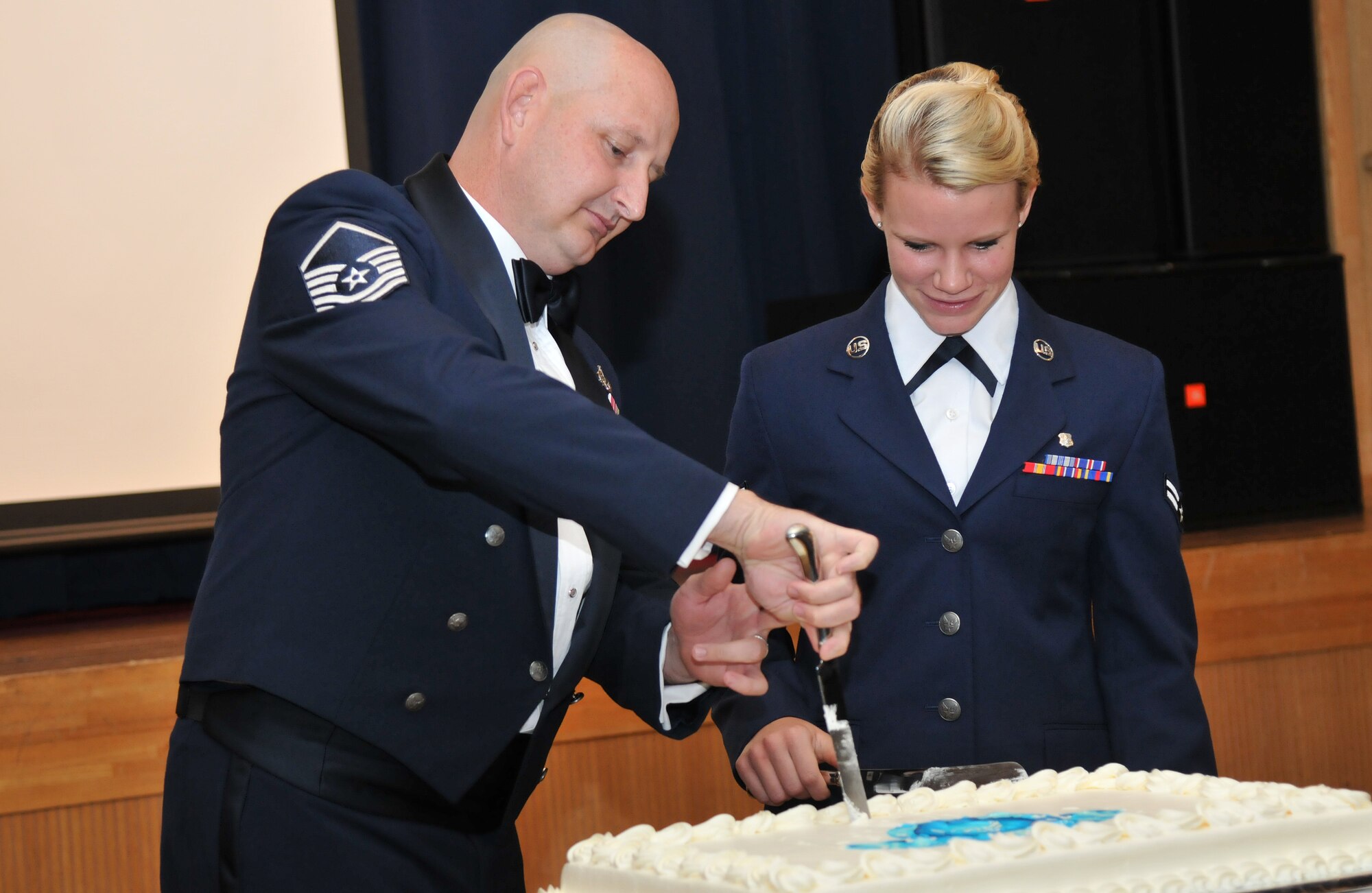 U.S. Air Force Master Sgt. David Cheney and Airman 1st Class Taylor Havlin take part in a cake-cutting ceremony during the 67th Annual Air Force Ball at Misawa Air Base, Japan, Sept. 20, 2014. Halvin was born in 1994, the same year Cheney enlisted in the Air Force. A senior NCO and a young Airman come together to cut the ceremonial cake at center stage as part of ball tradition. (U.S. Air Force photo by Senior Airman Jose L. Hernandez-Domitilo/Released)