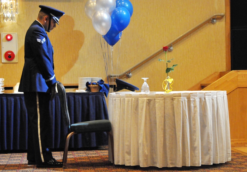 U.S. Air Force Senior Airman Juan Hernandez, 35th Maintenance Squadron aerospace propulsion journeyman, bows his head in remembrance of Prisoners of War and Missing in Action veterans during the 67th Annual Air Force Ball at Misawa Air Base, Japan, Sept. 20, 2014. As part of the ceremony, service members also toasted to past and present POW/MIAs. (U.S. Air Force photo by Senior Airman Jose L. Hernandez-Domitilo/Released)