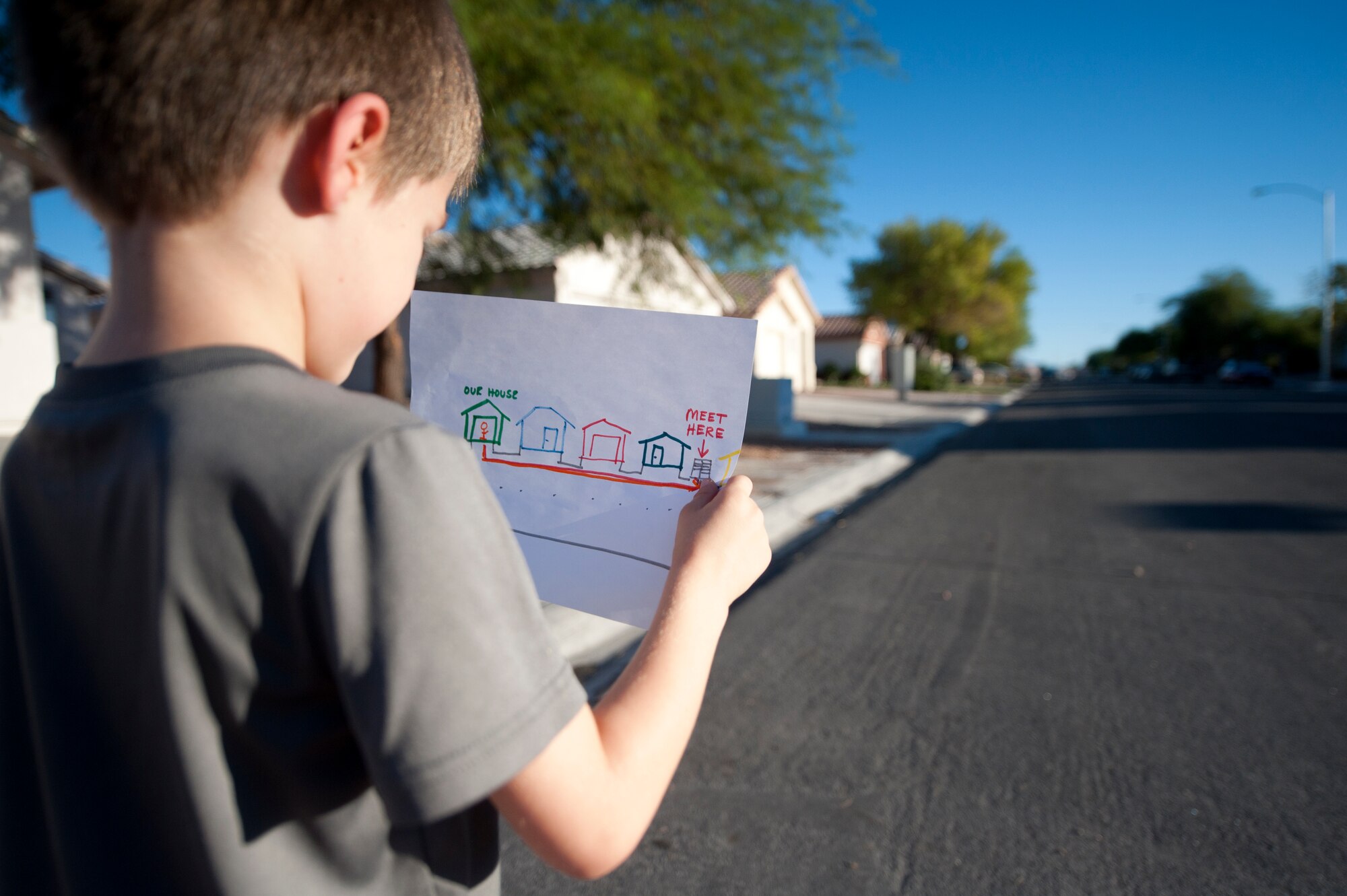 Aidan looks at drawing of his family’s designated meeting spot he would go to if an emergency or disaster forced him to leave his home in Las Vegas, Sept. 23, 2014. It is important to include children in the planning and practice of emergency sheltering or evacuation.  By making practice fun, kids are less likely to panic in stressful situations. (U.S. Air Force photo by Staff Sgt. Victoria Sneed)