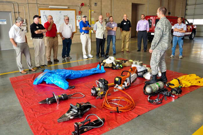 Senior Airman Eugene Dotson, 9th Civil Engineer Squadron firefighter, describes how military personnel cooperate with local agencies when responding to an emergency.  The honorary commanders visited the fire department during a base tour. (U.S. Air Force photo by Staff Sgt. Brenda Davis/Released)