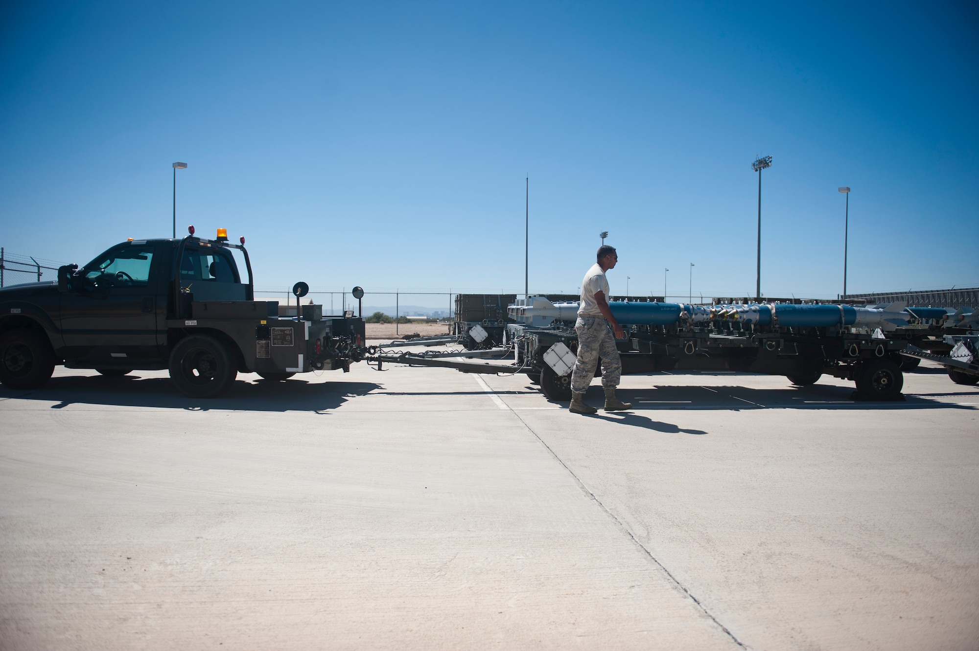 Senior Airman Miguel Vega, 57th Maintenance Squadron munitions line delivery crew chief, inspects munitions on his trailer before heading out to the flight line at Nellis Air Force Base, Nev., Sept. 19, 2014. Line delivery, or ‘Line-D,’ Airmen deliver all of the munitions assets from the munitions storage area to aircraft on the flight line. (U.S. Air Force photo by Staff Sgt. Siuta B. Ika)