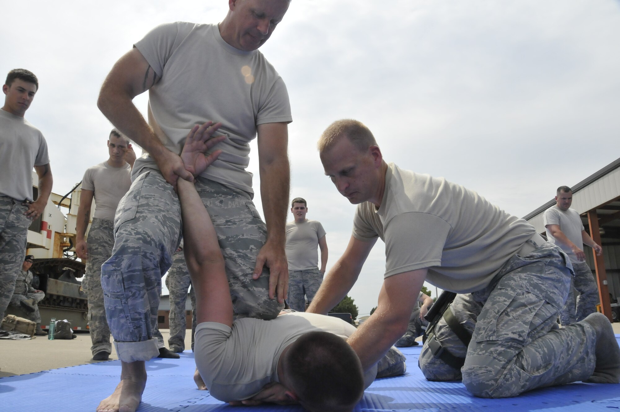 Tech. Sgt. Tim Holland, 188th Security Forces Squadron instructor (right) and Tech. Sgt. Bradley Hobbs, 188th Security Forces Squadron combative instructor, demonstrate an immobilizing technique on Senior Airman Mason Redding in a training event held at Ebbing Air National Guard Base, Fort Smith, Arkansas on Sept. 6, 2014. The event, held during a unit training assembly, strengthened the squadron’s mission readiness. (U.S. Air National Guard photo by Staff Sgt. John Suleski/Released)