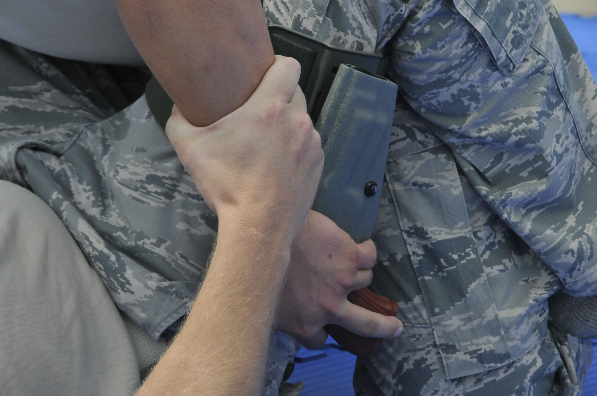A 188th Security Forces Squadron combative instructor and a training partner battle for control of a training pistol replica in a combative technique demonstration during a training event held at Ebbing Air National Guard Base, Fort Smith, Arkansas, Sept. 6, 2014. The event, held during a unit training assembly, strengthened the squadron’s mission readiness. (U.S. Air National Guard photo by Staff Sgt. John Suleski/Released)
