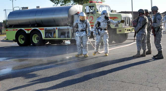 Firefighters from the 442d Fighter Wing prepare to hose down security forces members who have just finished a sweep of a ricin lab during an exercise at Whiteman AFB, Mo. on September 21. The Airmen represented two of the functional areas involved in the largest-scale disaster scenario to be attempted by the Reservist wing. The firefighters equipment was provided by Whiteman’s host unit, the 509th Bomb Wing. (Air Force photo by Tech. Sgt. Emily F. Alley) 