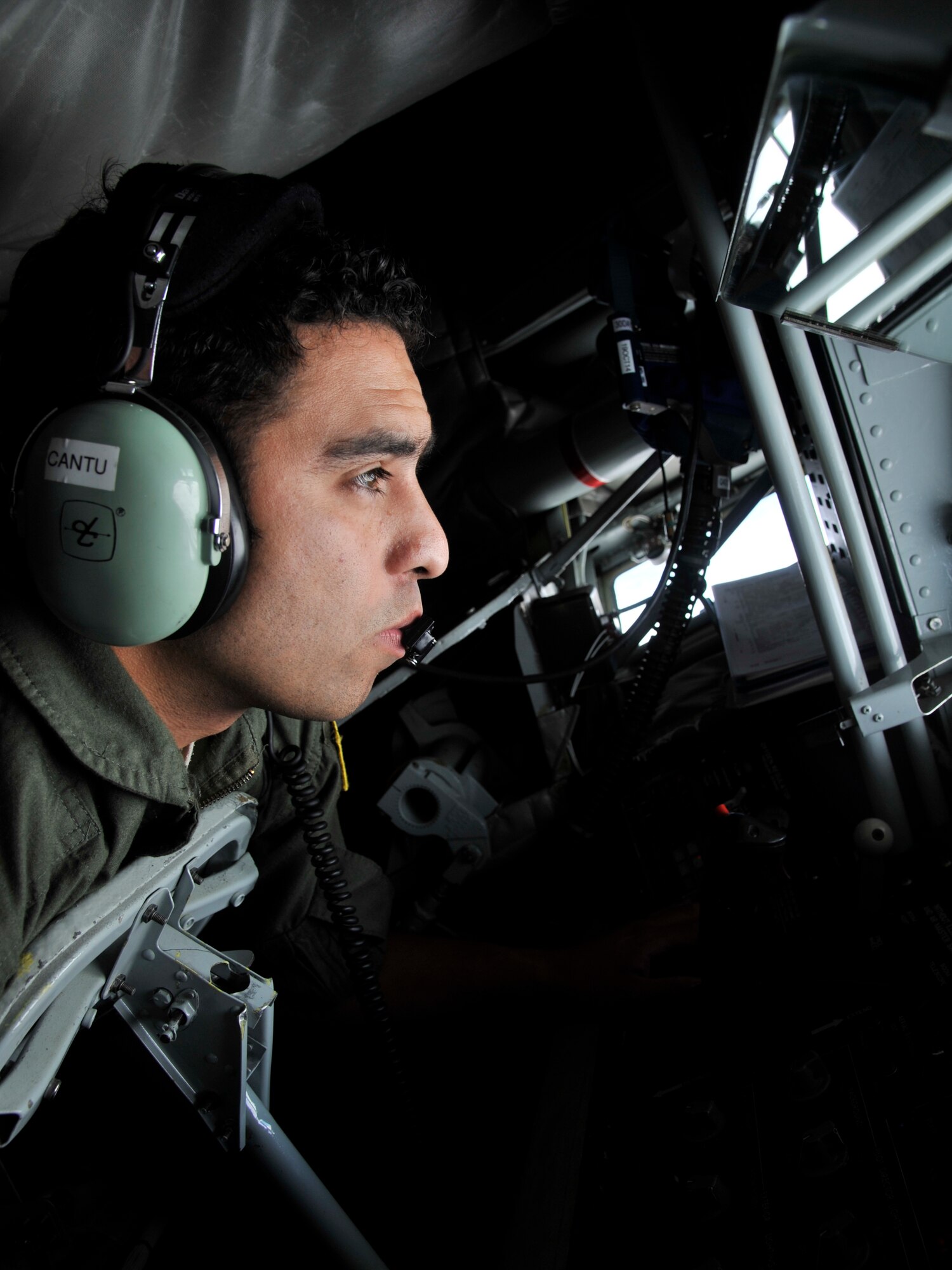 Staff Sgt. Steven Cantu prepares to refuel a B-1B Lancer assigned to Ellsworth Air Force Base, South Dakota, Sept. 23, 2014. Two B-1Bs were refueled by a KC-135 Stratotanker from Fairchild AFB, Washington, during a routine training mission over South Dakota. Nearly all internal fuel can be pumped through the flying boom, the KC-135's primary fuel transfer method. Cantu, a 92nd Air Refueling Squadron boom operator, is stationed in the rear of the plane and controls the boom during in-flight aerial refueling. (U.S. Air Force photo by Senior Airman Mary O'Dell/Released)