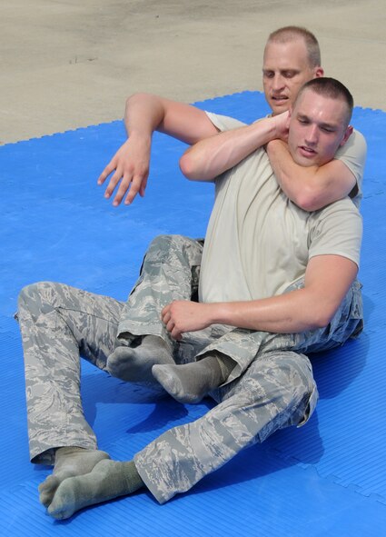 Tech. Sgt. Bradley C. Hobbs performs a move on Senior Airman Mason E. Redding during combative training at Ebbing Air National Guard Base, Fort Smith, Arkansas on Sept. 6, 2014. The Airmen are members of the 188th Security Forces Squadron (U.S. Air National Guard photo by Airman 1st Class Cody Martin/Released) 