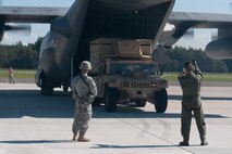 Air Force Tech. Sgt. Paul Jones (right), a loadmaster with the Kentucky Air National Guard’s 123rd Airlift Wing, directs the offloading of cargo from a Kentucky C-130 Hercules as the aircraft waits to depart an airfield in Latvia on Sept. 6, 2014, during Operation Saber Junction. The 123rd participated in the training exercise along with five other Air Guard units and troops from 17 NATO countries. (U.S. Air National Guard photo by 2nd Lt. James W. Killen)