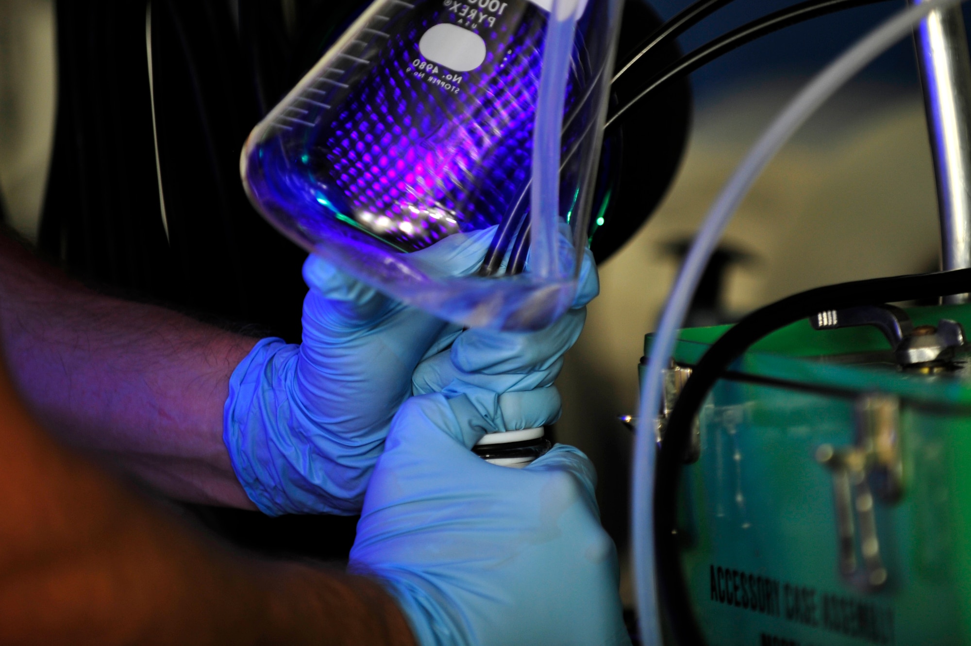 U.S. Air Force Staff Sgt. Jonathon Harris, 1st Maintenance Squadron Precision Measurement Equipment Laboratory craftsman, inspects fluids for contamination using a ultraviolet light at Langley Air Force Base, Va., Sept. 23, 2014. The laboratory technicians provide regional support for inspecting contaminations in equipment used on aircrafts. (U.S. Air Force photo by Airman 1st Class Breonna Veal) 