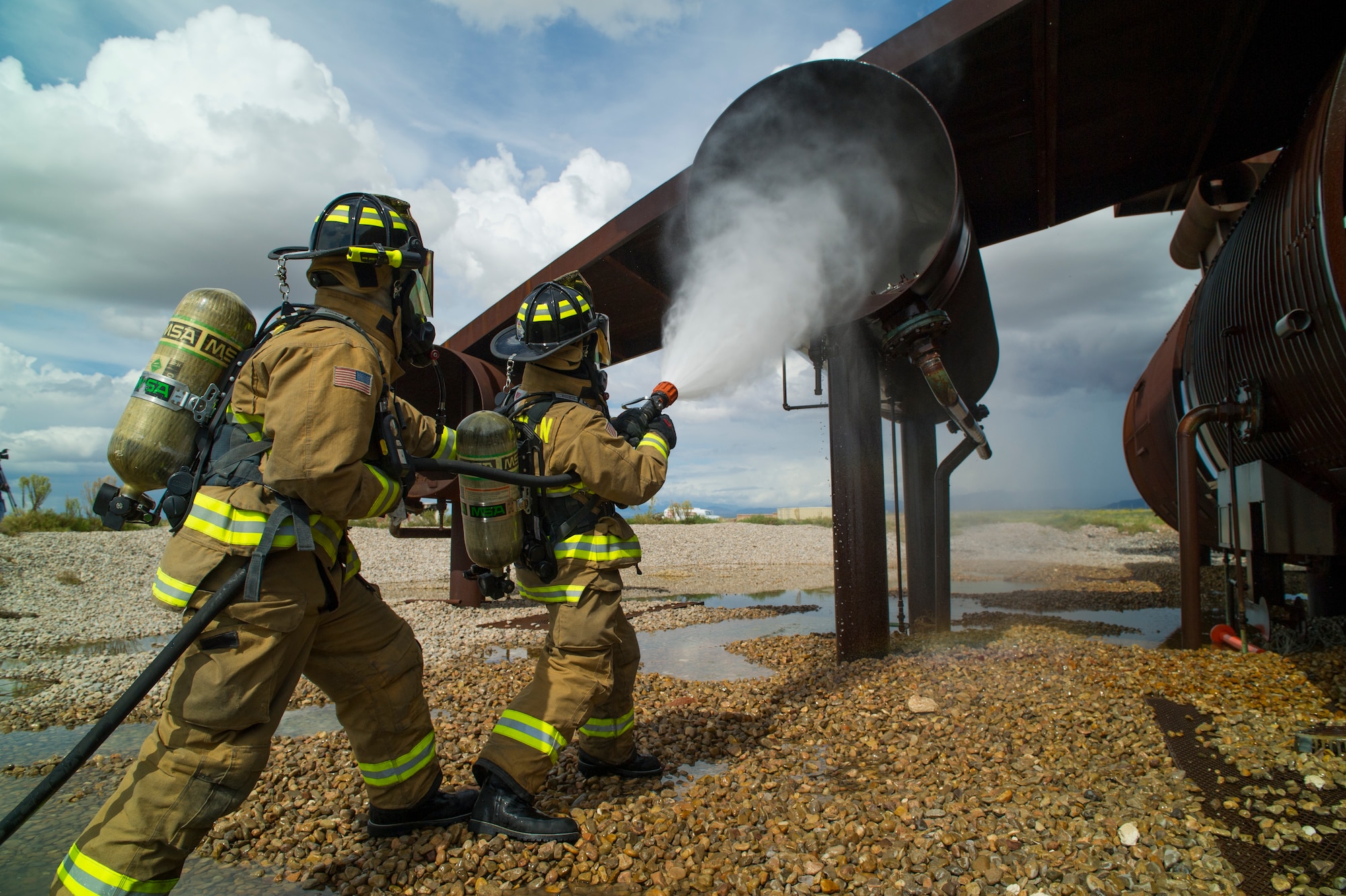 Staff Sgt. Phillip Daniels and Senior Airman Mark Dunford, 49th Civil Engineer Squadron Fire Protection Flight fire fighters extinguish a simulated number three engine fire during capability demonstration of the P-34 Rapid Intervention Vehicle at Holloman Air Force Base, N.M., Sept. 21. The RIV is three times more cost effective than the conventional firefighting vehicles. The combination of water and firefighting foam discharges at 1,350 pounds per square inch and increases the length of time that the RIV can remain on scene without having to be resupplied. Even though the RIV has a smaller capacity of 500 gallons, it has the firefighting capability of the larger 1,500 to 1,750 gallon vehicle at a cost that is significantly less. (U.S. Air Force photo by Airman 1st Class Aaron Montoya / Released)