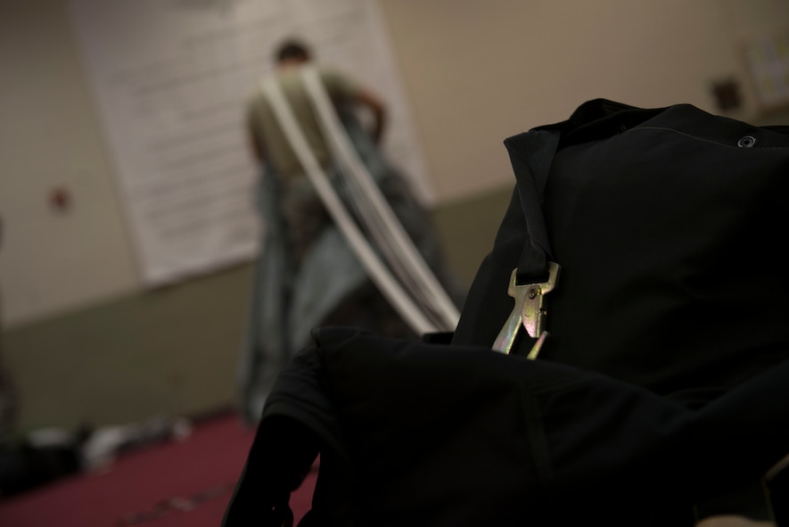 U.S. Air Force Senior Airman Matthew Purol, 38th Rescue Squadron aircrew flight equipment journeyman, checks a parachute for durability Sept. 23, 2014, at Moody Air Force Base, Ga. The 38th RQS AFE flight works directly for Guardian Angel, the Air Force’s only weapon system of individuals: pararescuemen, combat rescue officers and Survival, Evasion, Resistance, and Escape specialists. (U.S. Air Force photo by Airman 1st Class Dillian Bamman/Released)
