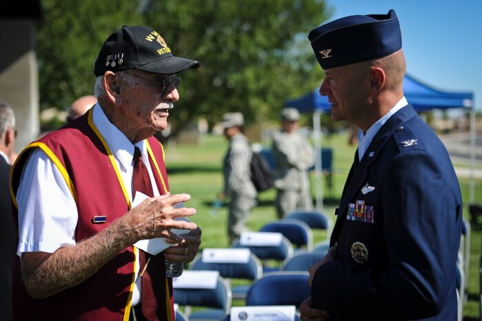 William Dean Whitaker, a World War II veteran and former prisoner of war, shares a story with Col. Thomas E. Dempsey III, Nevada Test and Training Range commander, during the Prisoner of War and Missing in Action Recognition Ceremony at Nellis Air Force Base, Nev., Sept. 19, 2014. Whitaker, who served in the U.S. Army Air Corps’ 603rd Bomb Squadron as a bombardier and navigator, was completing a mission over Merseburg, Germany when his B-17 was shot down on Nov. 2, 1944, and was subsequently held as a POW for seven months. Whitaker attends Nellis’ POW/MIA Recognition Ceremony every year to pay his respects and honor the legacy of his fallen brothers who were POWs or are still MIA. (U.S. Air Force photo by Staff Sgt. Siuta B. Ika)