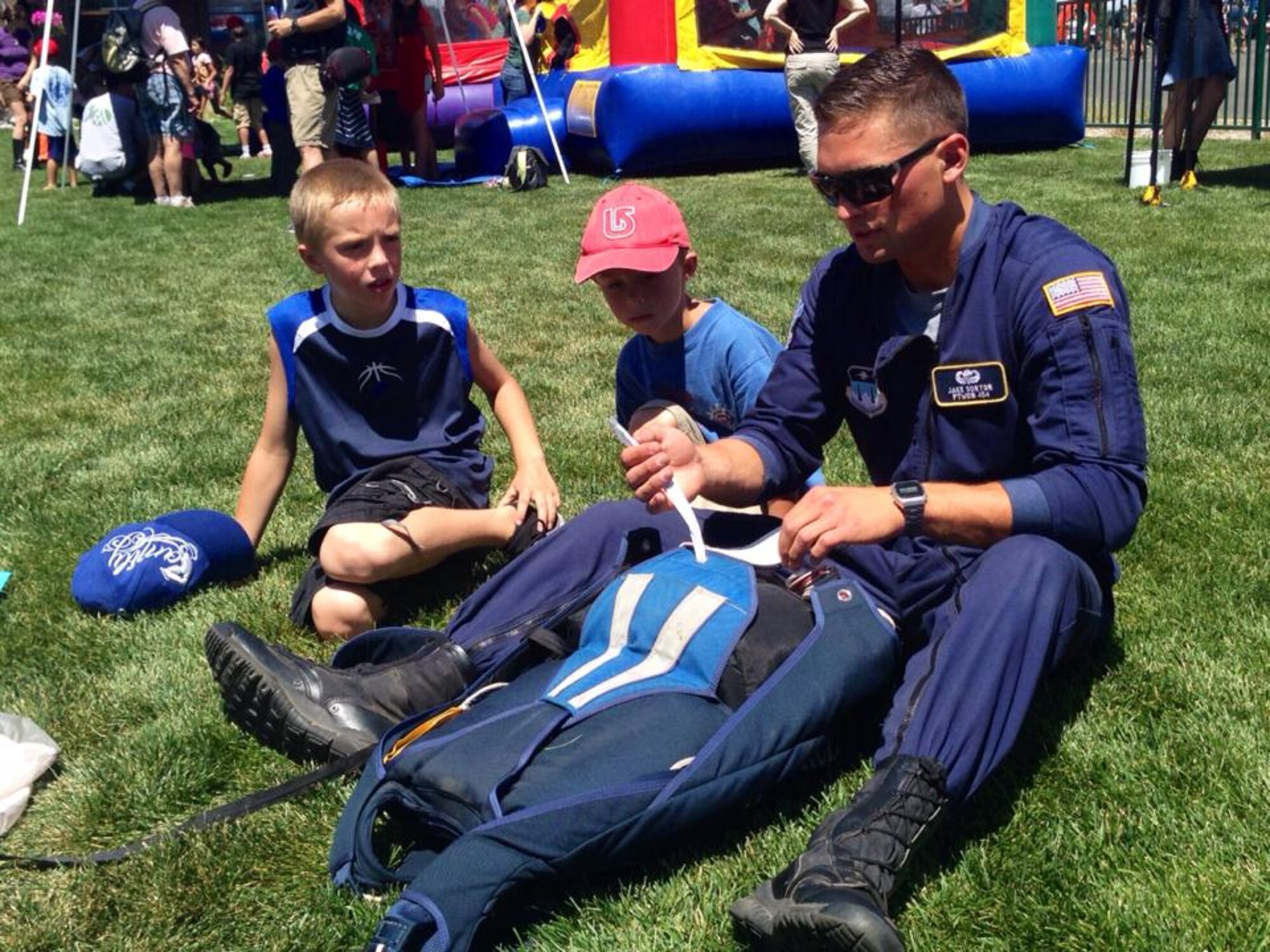 Cadet 1st Class Jake Sortor shows children how to pack a parachute at the Truckee-Tahoe Air Show and Family Festival in Truckee, Calif., in July. Sortor, the Academy’s Cadet Wing commander, is a Wings of Blue instructor. He and other WOB parachutists performed at the festival. (U.S. Air Force photo) 