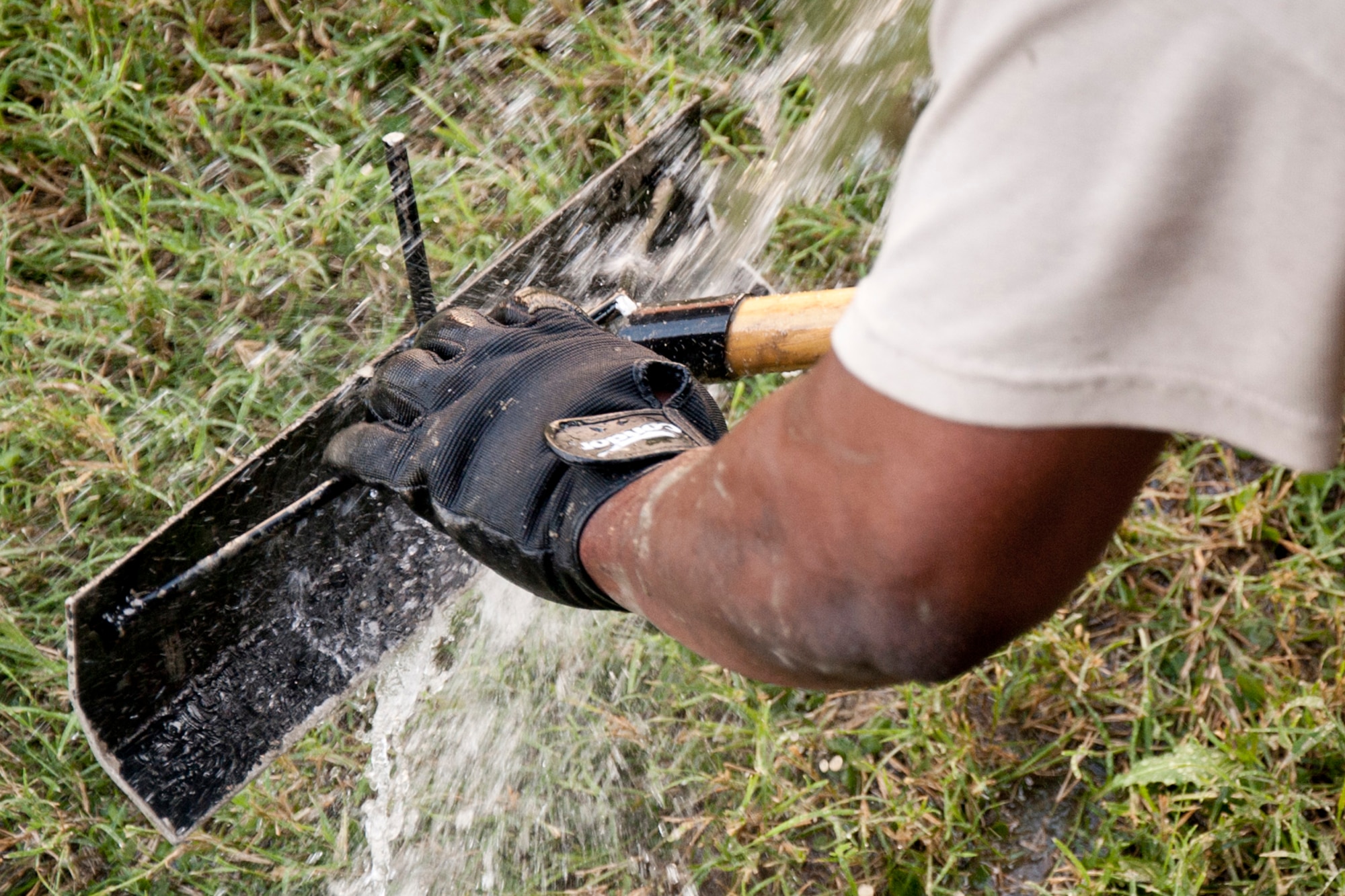 An Airman from the 307th RED HORSE cleans equipment after pouring a slab at the 93rd Bomb Squadron on Barksdale Air Force Base, La., Sept. 9, 2014. The new pad will be used for parking next to the building. (U.S. Air Force photo by Master Sgt. Jeff Walston/Released)