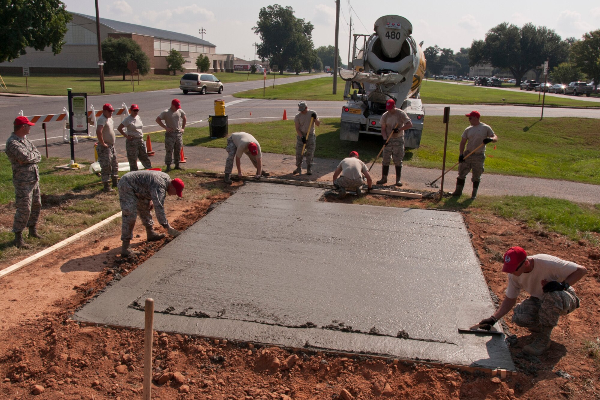 Airmen assigned to the 307th RED HORSE and 307th Civil Engineer Squadron strike off freshly placed concrete to make it as level as possible before finishing on Barksdale Air Force Base, La., Sept. 9, 2014. A fiber mix concrete, which contains no steel reinforcement, was used in this project. The new mix yields a smoother finish. (U.S. Air Force photo by Master Sgt. Jeff Walston/Released)