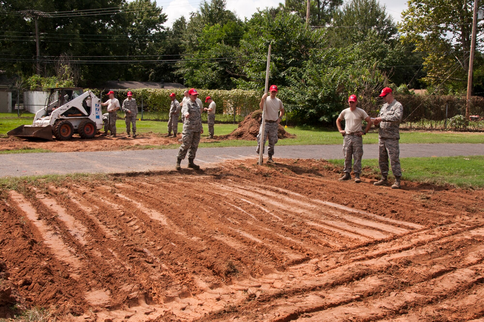 Members of the 307th RED HORSE and 307th Civil Engineer Squadron prepare ground for two of three additional fitness areas being built along a running trail on Barksdale Air Force Base, La., Sept. 8, 2014. Exercise equipment to be installed on the pads have smart phone capabilities, and will allow the athlete an opportunity to watch videos on how to properly use each piece of equipment and several examples of different exercises. (U.S. Air Force photo by Master Sgt. Jeff Walston/Released)
