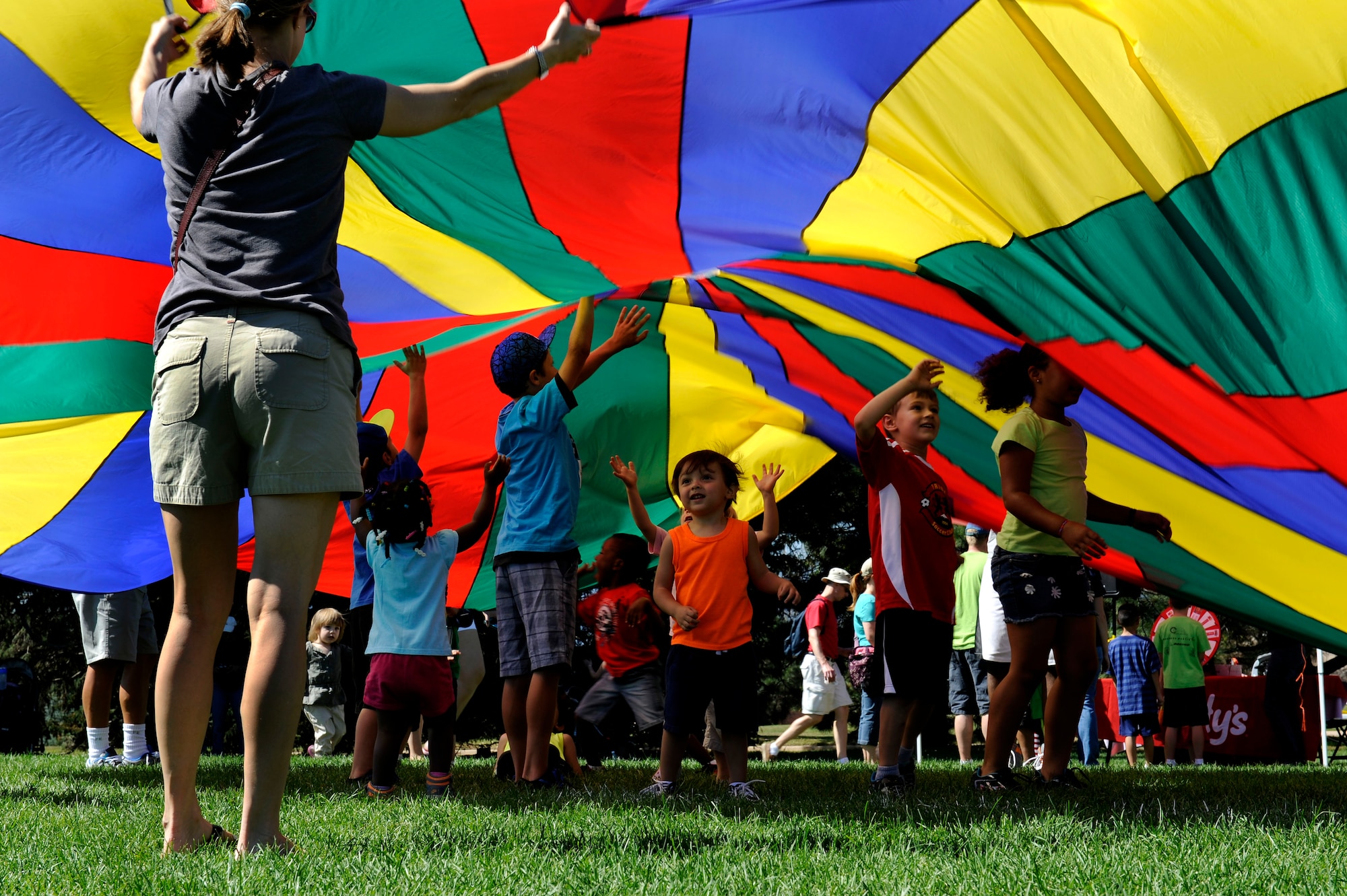PETERSON AIR FORCE BASE, Colo. - Children play under the giant parachute at the World Wide Day of Play held at Patriot Park Sept. 20 and hosted by the RP Lee Youth Center. Worldwide Day of Play is an annual event designed to encourage children and parents to turn off the television and get outside and play. (U.S. Air Force photo/Airman 1st Class Rose Gudex)
