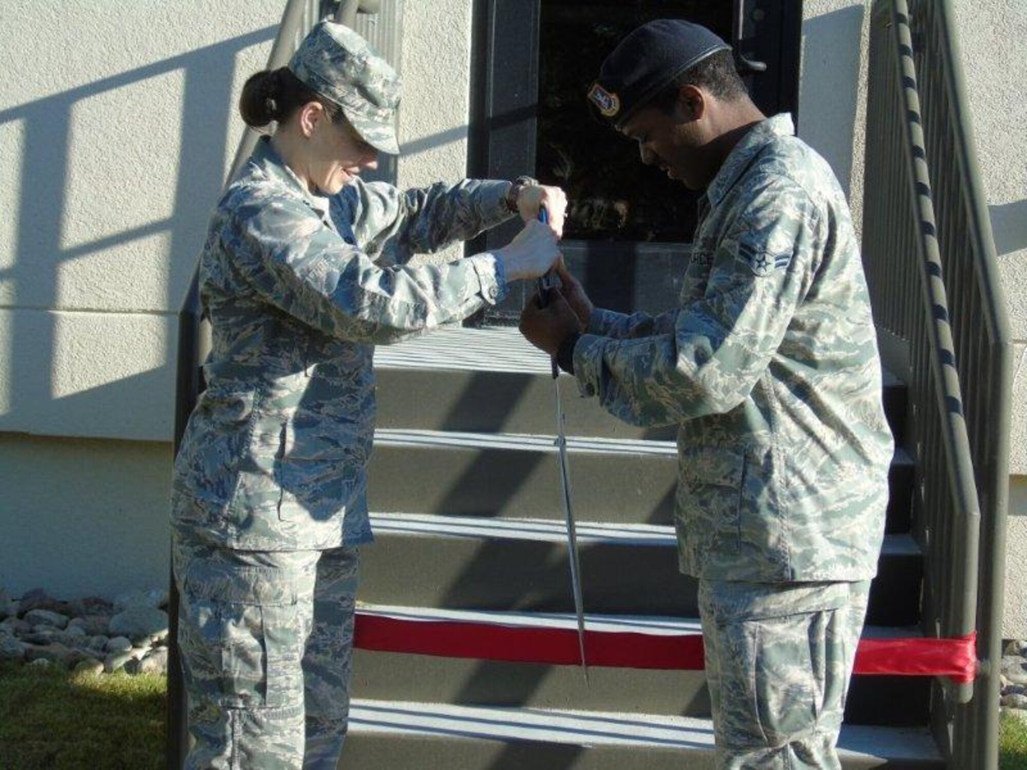 CAVALIER AIR FORCE STATION, N.D. - Lt. Col. Michelle Kneupper, 10th Space Warning Squadron commander, and Airman 1st Class Craig Bellamy, 319th Security Forces Security Squadron response team member, cut the ribbon to the new security forces alert facility at Cavalier Air Force Station, N.D. Sept. 15. The $2.6 million renovation began Aug. 5, 2013, and replaced the former 40-year-old facility. (U.S. Air Force courtesy photo)