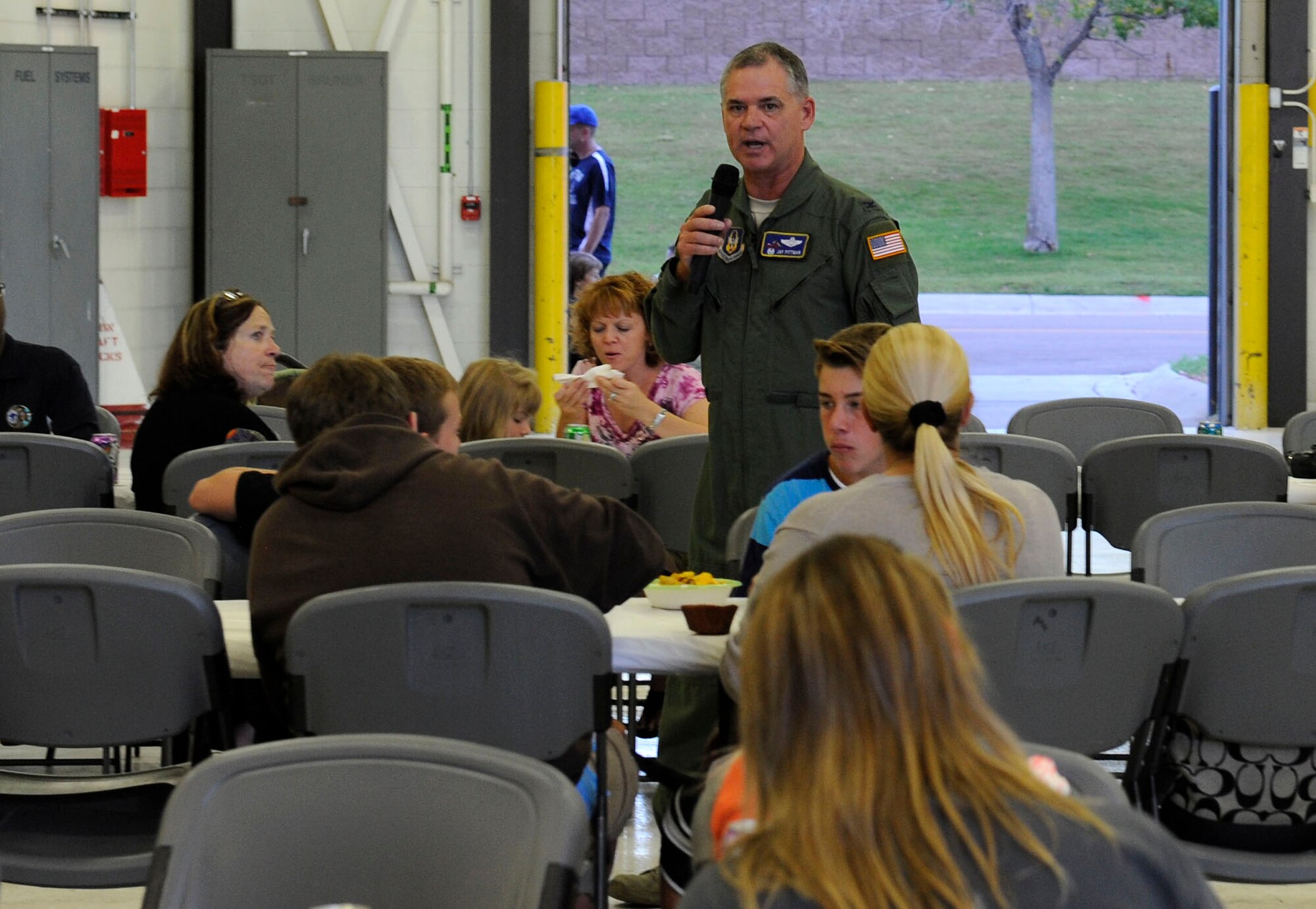 Col. Jack Pittman, 302nd Airlift Wing commander, talks to the crowd at the Deployed Families’ Dinner in Hangar 210 on Sept. 19. The Deployed Families’ Dinner is held once a month for families to get together and have a little fun and a support system while their loved ones are overseas. (U.S. Air Force photo/Airman 1st Class Rose Gudex)