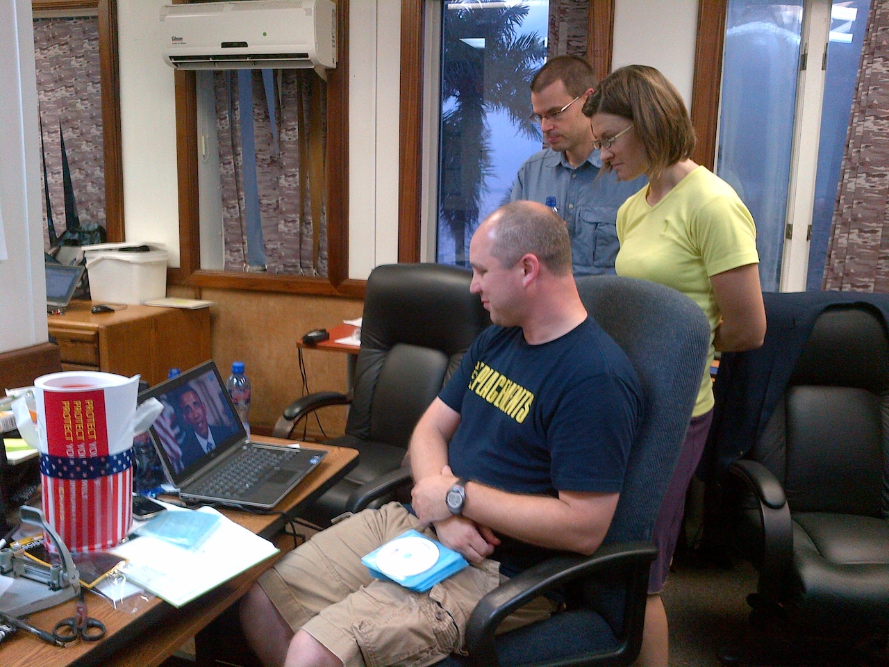 U.S. Centers for Disease Control and Prevention disease detectives -- epidemiologists Kevin, Karlyn and Adam -- review President Barack Obama's Sept. 2, 2014, video message to the people of West Africa before departing for the Liberian counties of Grand Kru, Grand Gedeh, Maryland, Rivercess, River Gee and Sino. Sent to West Africa during the 2014 Ebola virus disease outbreak, while in the field the epidemiologists will help county and district health officials establish and strengthen patient screening, infection control and patient isolation measures. The Ebola outbreak is affecting Liberia, Sierra Leone, Guinea and Nigeria. CDC photo by Sally Ezra