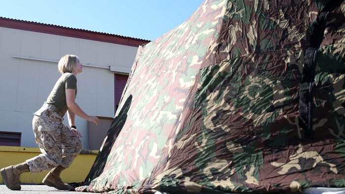 Private Sarah Trull, a fiscal clerk with Marine Air Group 39, puts together an Arctic shelter Aug. 29, 2014, aboard Camp Pendleton, California. The system is an ultra-lightweight, rapidly deployable shelter that offers military forces the necessary infrastructure to operate in austere cold-weather locations. The system is being used for training exercises in Bridgeport, California, and is slated to be integrated into exercises early next year. 