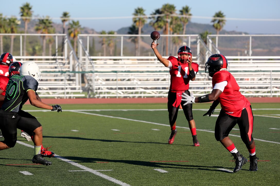 Derek Nichols, Marine Corps Air Station Miramar Falcons’ quarterback, throws a pass to Ship’s Serviceman 3rd Class Patrick Williams, Falcons’ fullback, against the Marine Corps Base Camp Pendleton Headquarters Support Battalion Spartans at Paige Field House aboard MCB Camp Pendleton, Calif., Sept. 23. The Falcons lost to the Spartans 36-0.