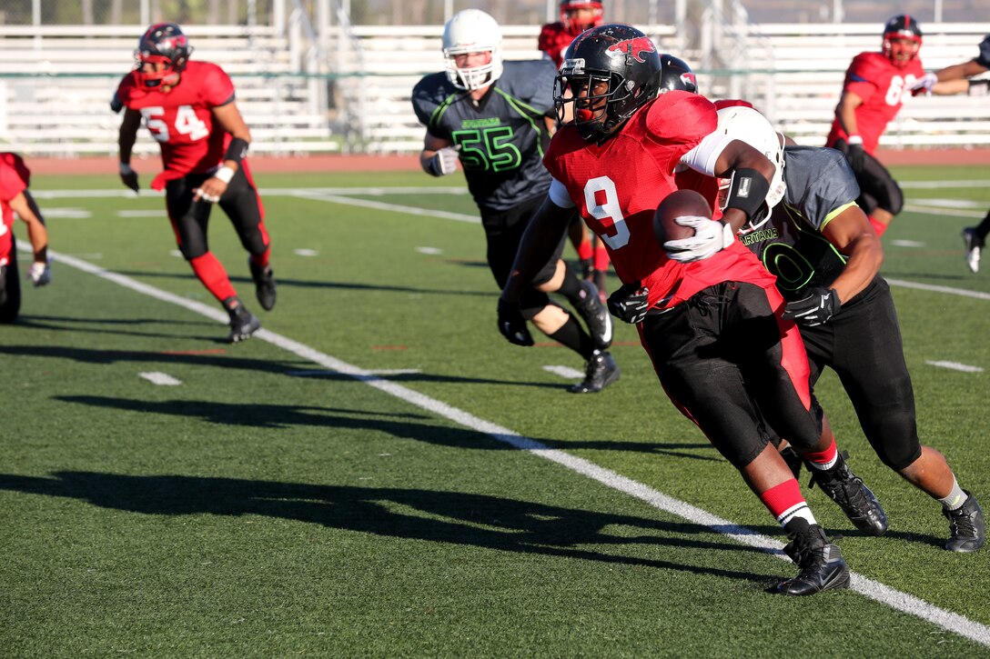 Patrick Williams, Marine Corps Air Station Miramar Falcons’ fullback, sheds a Marine Corps Base Camp Pendleton Headquarters Support Battalion Spartans defender during a football game at Paige Fields House aboard MCB Camp Pendleton, Calif., Sept. 23. The Falcons fell short to the Spartans 36-0.