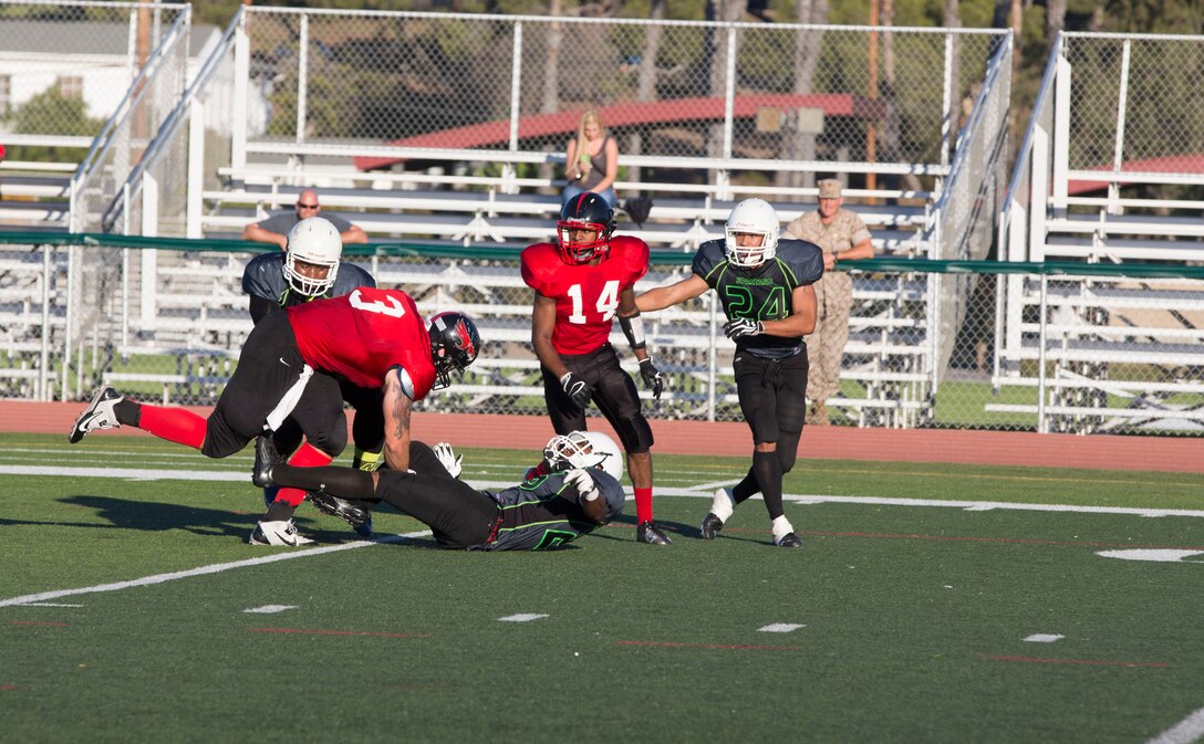 Ian Sumner, Marine Corps Air Station Miramar Falcons’ wide receiver, runs through a Marine Corps Base Camp Pendleton Headquarters Support Battalion Spartans defender at Paige Field House aboard MCB Camp Pendleton, Calif., Sept. 23. The Falcons were defeated by the Spartans 36-0 in their first loss of the season.