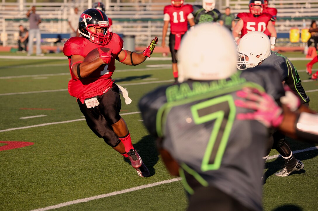 Kyle Byrdsong, Marine Corps Air Station Miramar Falcons’ wide receiver, dodges a Marine Corps Base Camp Pendleton Headquarters Support Battalion Spartans defender during a game at Paige Field House aboard MCB Camp Pendleton, Calif., Sept. 23. The Falcons suffered defeat, losing to the Spartans 36-0. 