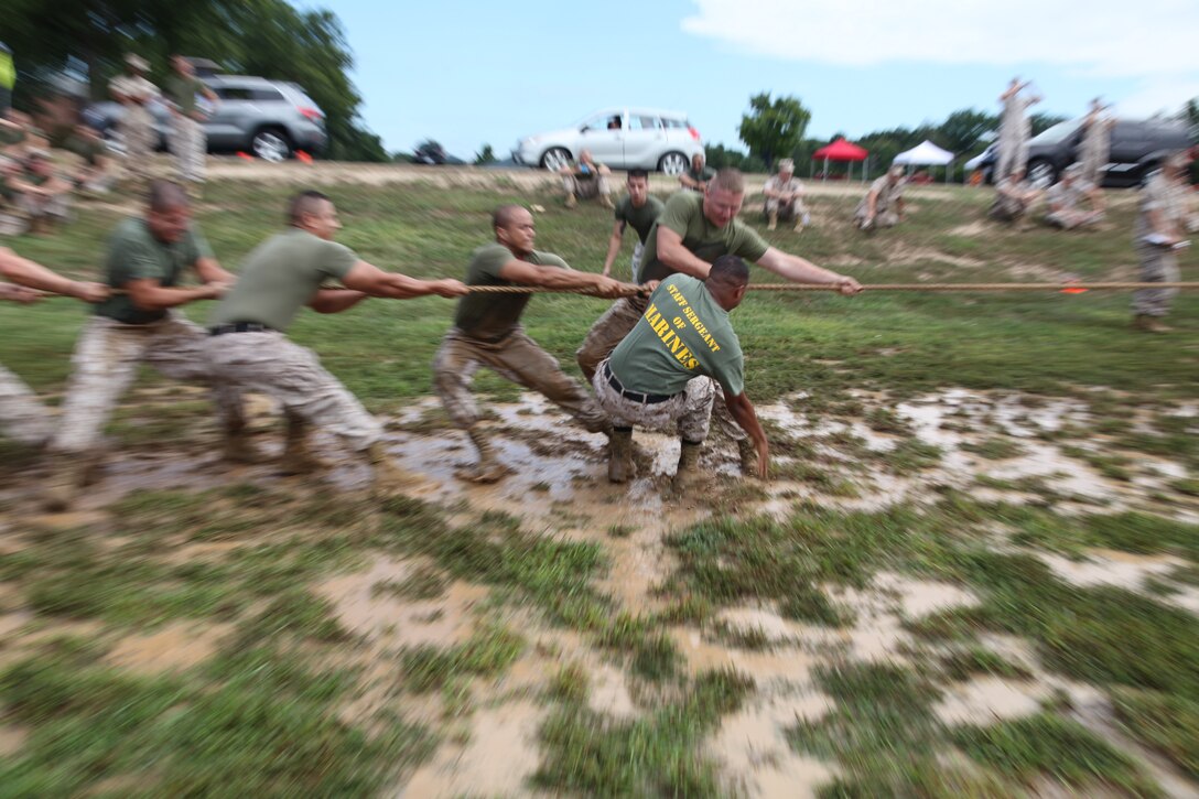 A Marine, right, reaches out to steady himself as he slips in the mud during the tug-of-war competition of the Headquarters and Service Battalion field meet Sept. 12, 2014, at Barnett and Steam fields. 
