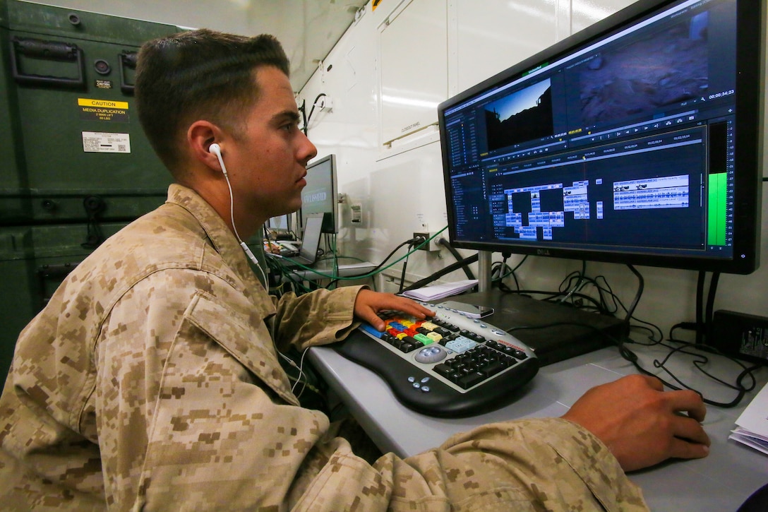 U.S. Marine Corps Cpl. Donald Holbert with 1st Marine Division Combat Camera edits video footage in a Tactical Imagery Production System (TIPS), during Exercise Desert Scimitar 14 aboard Marine Corps Air Ground Combat Center Twentynine Palms, Calif., May 11, 2014. The TIPS is a self-contained tactical shelter system with imagery and reproduction capabilities for utilization in forward operational areas. (U.S. Marine Corps photo by Staff Sgt. Ben J. Flores, 1st Marine Division Combat Camera/Released) 