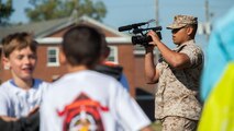 U.S. Marine Corps Lance Cpl. Rafael Rodriguez, combat videographer with Combat Camera, G-3/5, Marine Corps Installation East, records video of families participating in the units Kids Boot Camp at the Goettge Memorial Field House aboard Camp Lejeune, N.C., April 24, 2014. The event was held to commemorate National Take Your Child to Work Day. (U.S. Marine Corps photo by Sgt. Christopher Q. Stone/COMCAM, MCI-East, Camp Lejeune/Released)