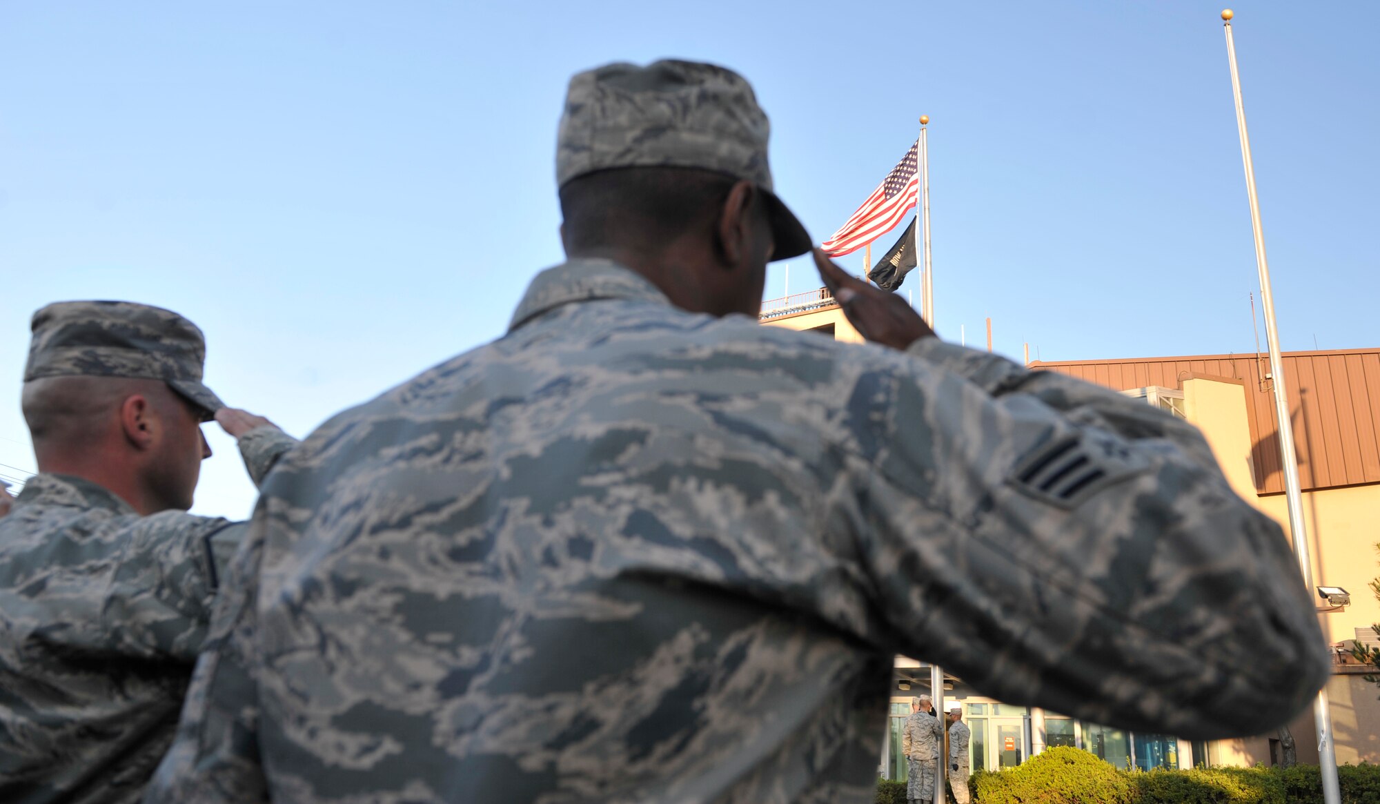 Airmen salute the flags during the POW/MIA remembrance ceremony Sept. 19, 2014 on Osan Air Base, Republic of Korea. This annual event honors the prisoners of war and those who went missing in action. (U.S. Air Force photo by Senior Airman David Owsianka)