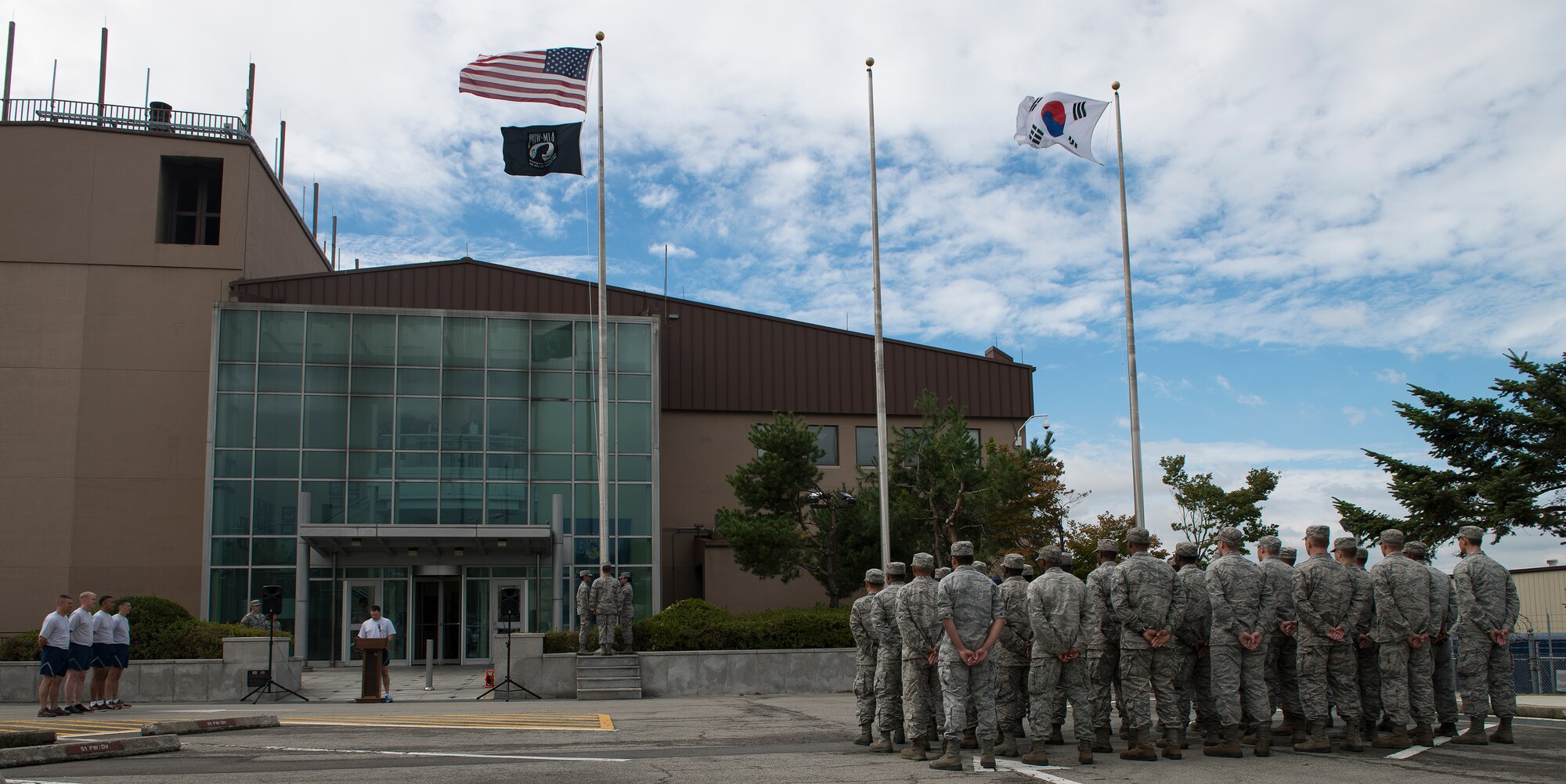 Team Osan stands by before a retreat ceremony Sept. 24, 2014, at Osan Air Base, Republic of Korea. The retreat ceremony was in honor of Prisoners of War and Missing in Action. POW/MIA remembrance day is traditionally observed on the third Friday of September each year, and Osan Air Base honored this tradition by observing a POW/MIA remembrance week Sept. 19 - 26. (U.S. Air Force photo by Staff Sgt. Jake Barreiro/Released)