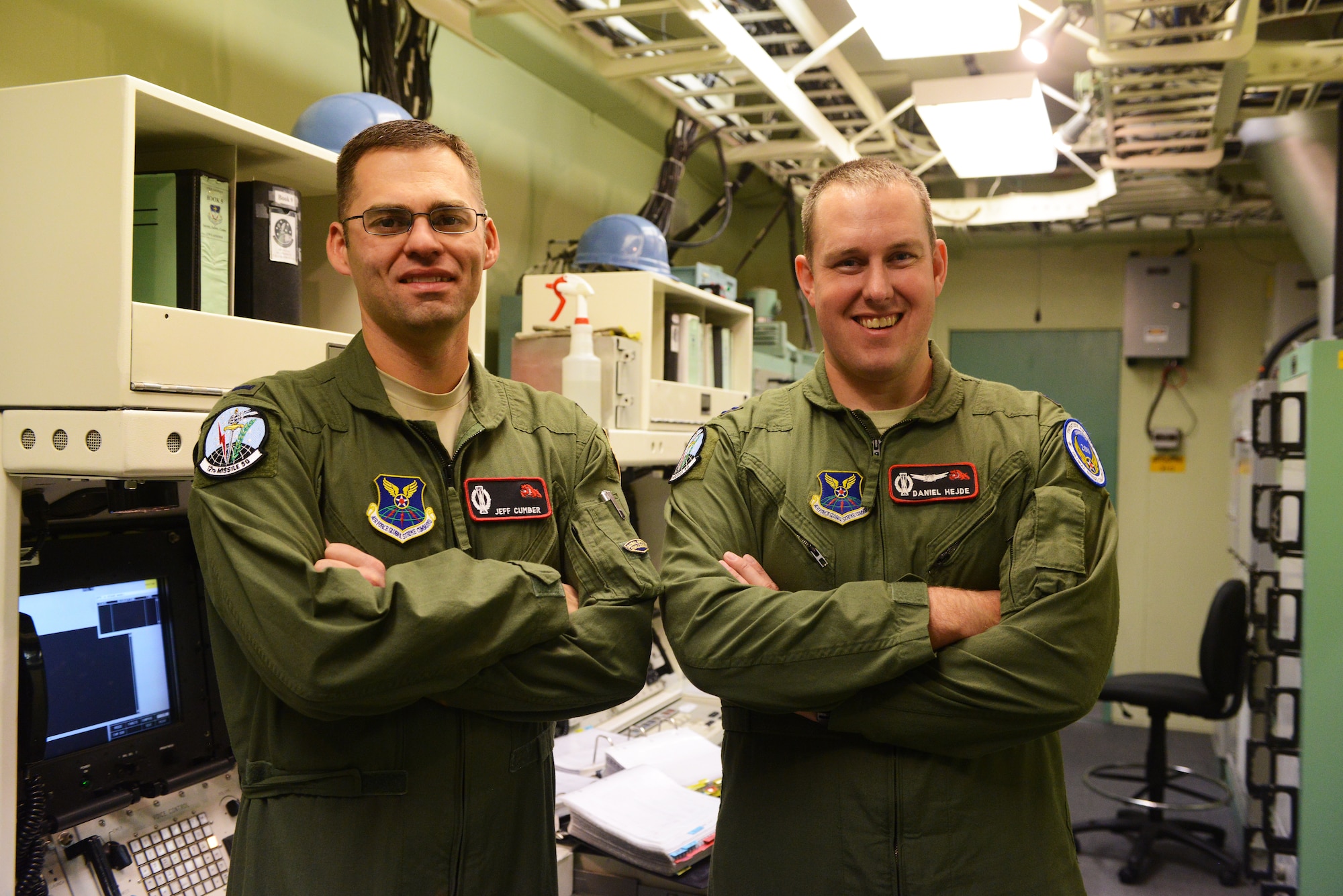 1st Lt. Jeff Cumber, 12th Missile Squadron deputy missile combat crew commander (left), and Capt. Dan Hejde, 12th MS combat missile crew commander, pose for a photograph after a training session at Malmstrom Air Force Base Sept. 24. The team is one of nine from the base that will be competing in the 2014 Air Force Global Strike Challenge. (U.S. Air Force photo/Airman 1st Class Collin Schmidt)