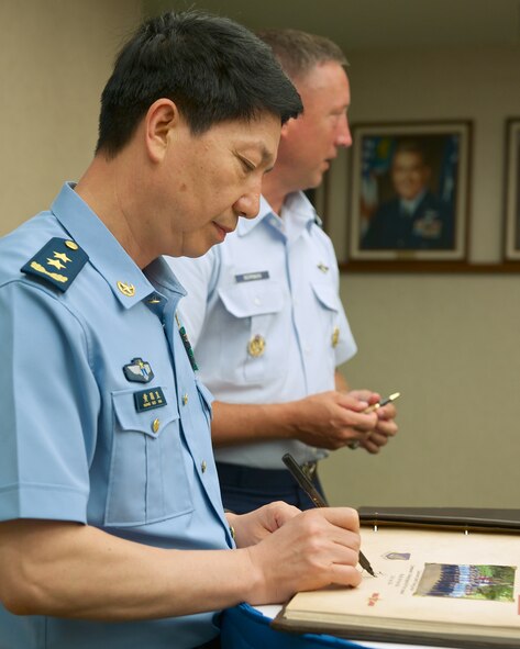 Lt. Gen. Huang Guoxian, commander Nanjing Military Regional Air Force Command, signs a visitor guest book during a visit to Pacific Air Forces headquarters, Sept. 23, 2014, Joint Base Pearl Harbor-Hickam, Hawaii.  Huang and a delegation of People's Liberation Army Air Force officers visited Pacific Air Forces as part of ongoing efforts to build a strong military to military relationship between the U.S. and China. (U.S. Air Force photo by Tech. Sgt. James Stewart/Not Released)(U.S. Air Force photo by Tech. Sgt. James Stewart/Released)