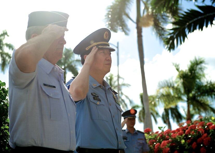 Gen. Hawk Carlisle, Pacific Air Forces commander (left), and Lt. Gen. Huang Guoxian (right), commander Nanjing Military Regional Air Force Command, render salutes before passing through an honor guard cordon, Sept. 23, 2014, Joint Base Pearl Harbor-Hickam, Hawaii.  Carlisle hosted Huang and a delegation of People's Liberation Army Air Force officers as part of a reciprocal visit key to building a strong military to military relationship between the U.S. and China. (U.S. Air Force photo by Tech. Sgt. James Stewart/Released)