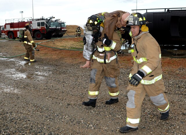 Beale firefighters rescue a simulated victim during an aircraft emergency exercise Sept. 25, 2014, here. The exercise was conducted to evaluate the installations emergency services procedures. (U.S. Air Force photo by John Schwab/Released)