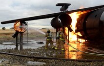 Beale firefighters combat a simulated aircraft fire during an aircraft emergency exercise Sept. 25, 2014, here. Beale firefighters routinely train at the aircraft simulation pit to hone their skills and showcase their abilities to fire department leadership.  (U.S. Air Force photo by John Schwab/Released)