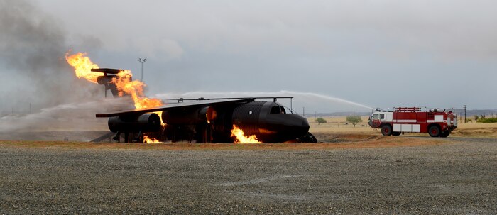 A Beale fire truck sprays down a simulated aircraft fire during an aircraft emergency exercise Sept. 25, 2014, here. Seven vehicles and 17 firefighters responded to the exercise. (U.S. Air Force photo by John Schwab/Released)