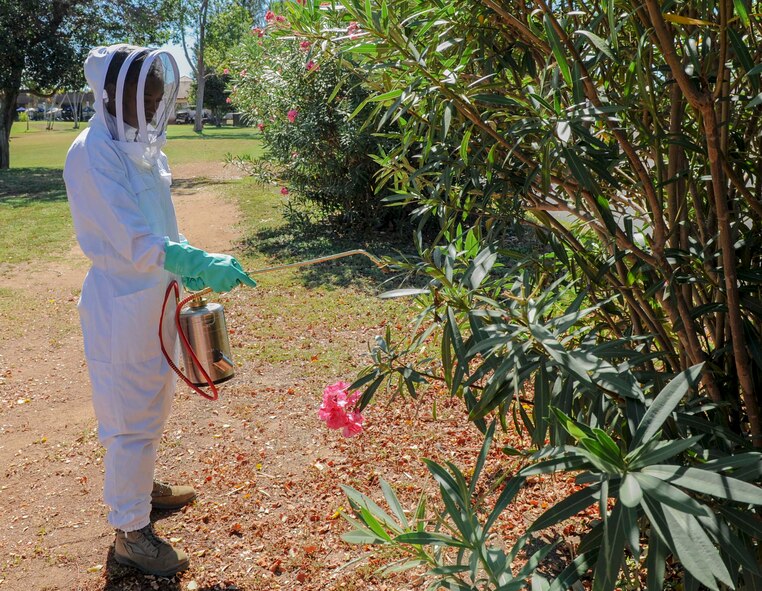Senior Airman Joy Cooper, 647th Civil Engineer Squadron Entomology Flight journeyman, sprays for bees on the golf course at Joint Base Pearl Harbor-Hickam, Hawaii, Sept. 23, 2014. The entomology flight serves as pest control for the base. (U.S. Air Force photo/Tech. Sgt. Terri Paden)