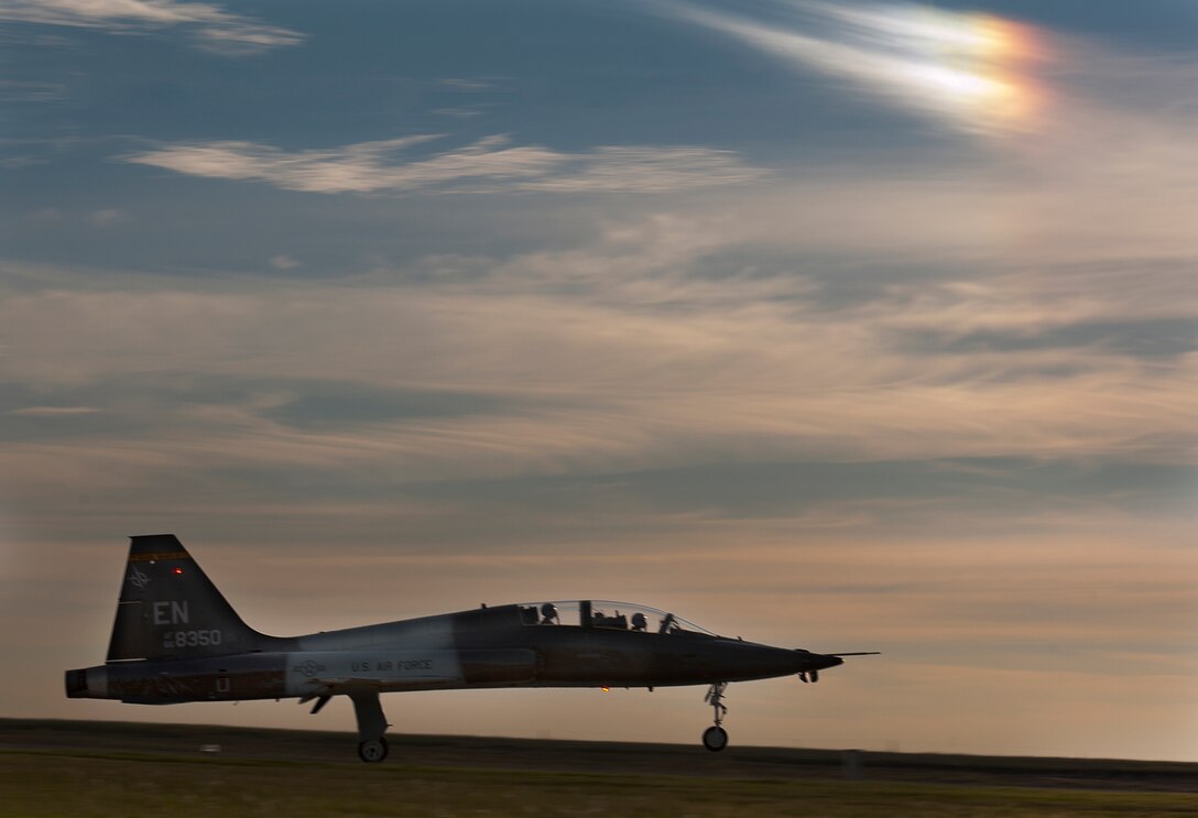 An air crew from the 80TH Flying Training Wing takes off down the runway to practice maneuvers during pilot training in T-38 Talon aircrafts on Sept 25, 2014 at Sheppard Air Force Base, Texas. A portion of a rainbow shines through the sky as pilots practice take offs, landing, touch and goes and tactical formation. (U.S. Air Force photo by Danny Webb/Released)  