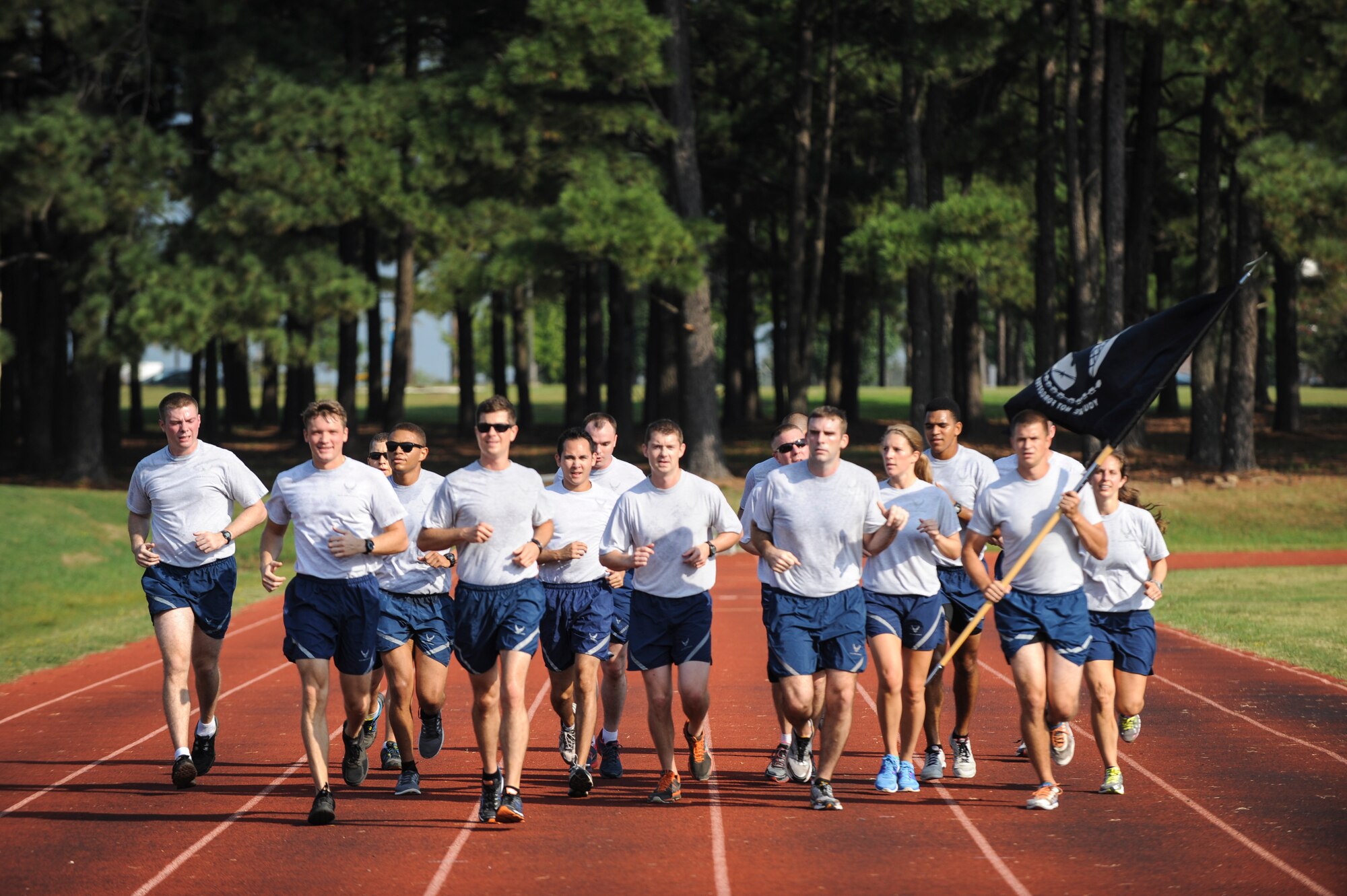 Airmen from the 61st Airlift Squadron run during the Prisoner of War/Missing in Action Recognition Day run Sept. 19, 2014, at Little Rock Air Force Base, Ark. The run involved hundreds of Airmen from units across the installations participating in one-hour shifts to keep the POW/MIA flag in motion, non-stop for the entire 24-hour event.  (U.S. Air Force photo by Airman 1st Class Cliffton Dolezal)