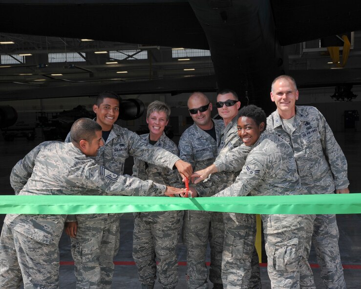 Col. Kristin Goodwin, 2nd Bomb Wing commander, Col. David Foote, 2nd Maintenance Group commander, and Airmen from the 2nd MXG cut the ribbon during a ceremony held for the 2nd Maintenance Group Weapons Load Training Facility on Barksdale Air Force Base, La., Sept. 19, 2014. The facility will add another degree of versatility to the 2nd MXG by providing adequate cover for weapons loaders in the case of inclement weather. (U.S. Air Force photo/Senior Airman Jannelle Dickey)