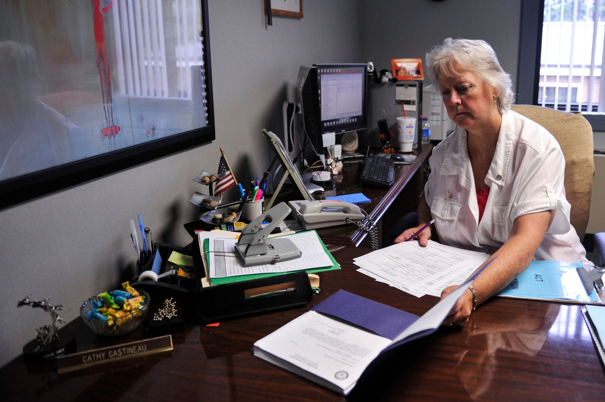 Cathy Gastineau, 19th Airlift Wing Office of the Staff Judge Advocate discharge clerk, builds discharge packages Sept. 16, 2014, at Little Rock Air Force Base, Ark. Gastineau works mainly with Little Rock AFB first sergeants, making sure discharge packages are accurately drafted and organized for the involuntary separation of Airmen.  (U.S. Air Force photo by Senior Airman Regina Agoha)