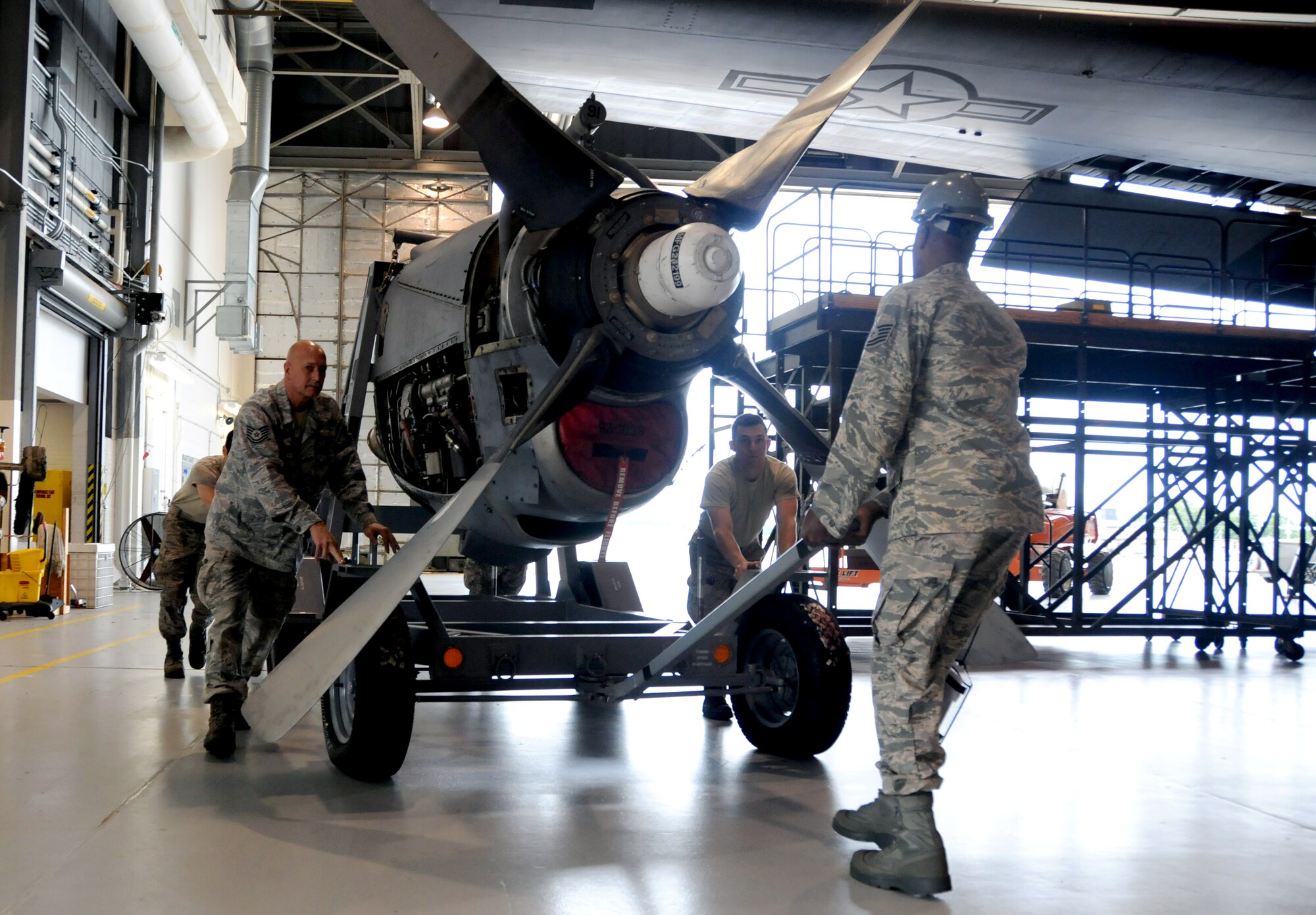 Airmen of the 94th Maintenance Squadron move the engine of a C-130 Hercules at Dobbins Air Reserve Base, Ga., Sept. 25, 2014. On Sept. 29, the 94th Airlift Wing is sending one C-130 and a team of 44 Airmen to partake in RED FLAG-Alaska 15-1. (U.S. Air Force photo by Senior Airman Daniel Phelps/Released)